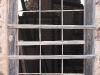 Peering through an old window on the side of a house at the Vulture Mine tour